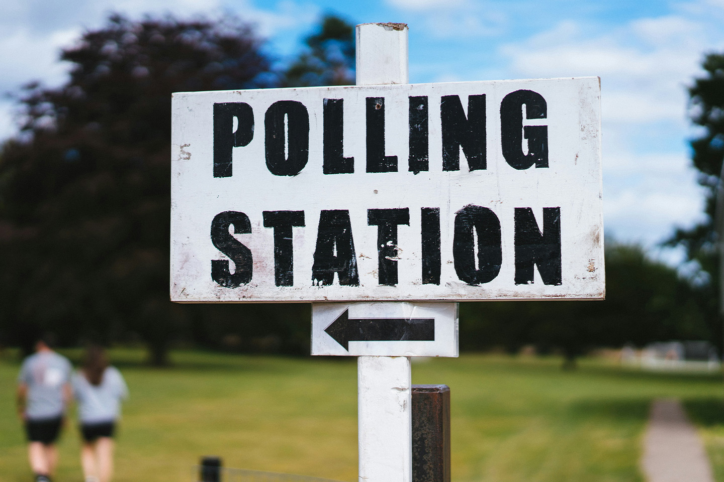 white wooden sign with the words 'polling station' written on it along with an arrow pointing to the left