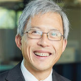 Image of a man with grey hair and glasses smiling at the camera
