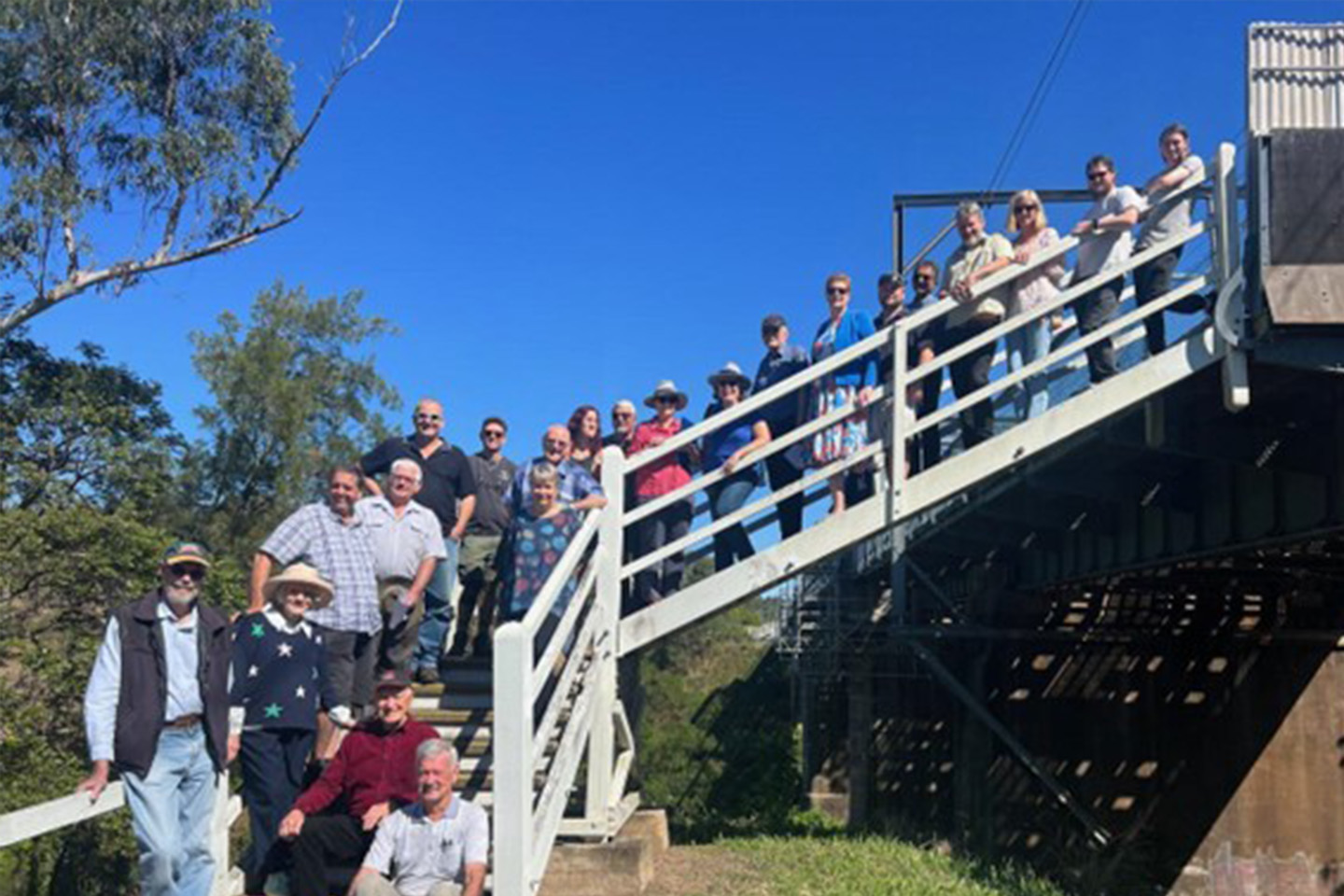 A group of people standing on a set of stairs outside posing for a photo
