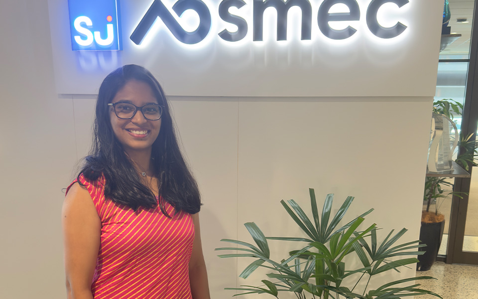 Image of graduate engineers Mansi Mate standing in front of SMEC sign