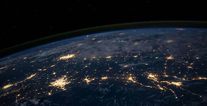 The globe pictured from afar at night, orange lights are showing