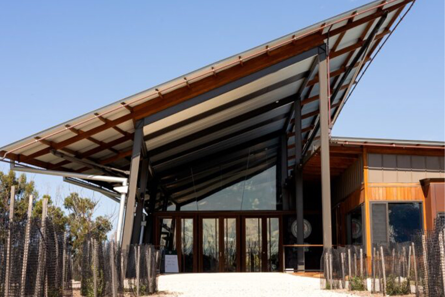 Image of a house with a slanted roof, blue sky in background.
