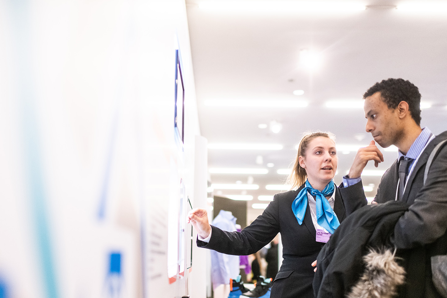 A woman and man looking at a notice board