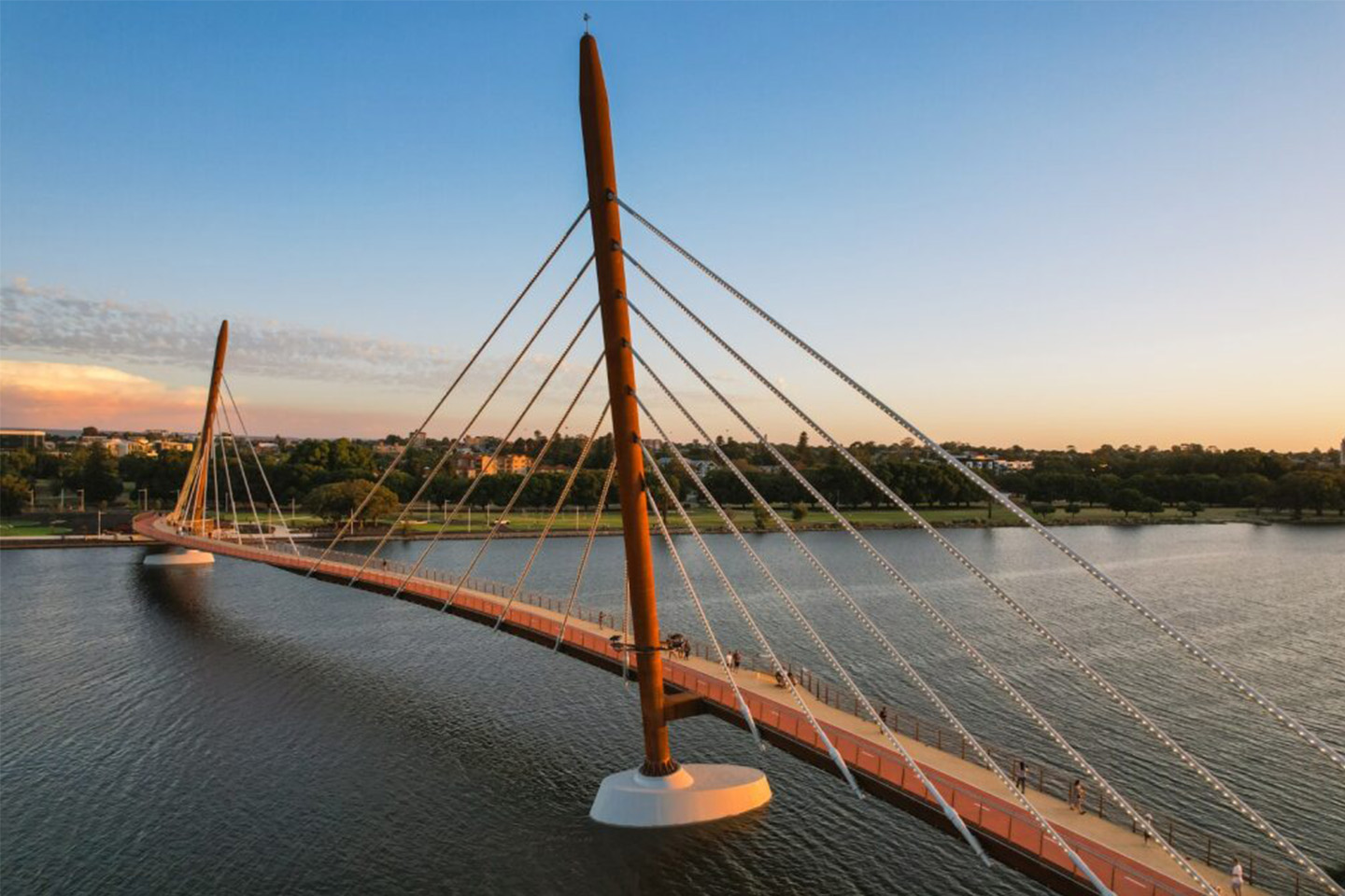 Image of a large bridge over a huge body of water, sunsetting in the background