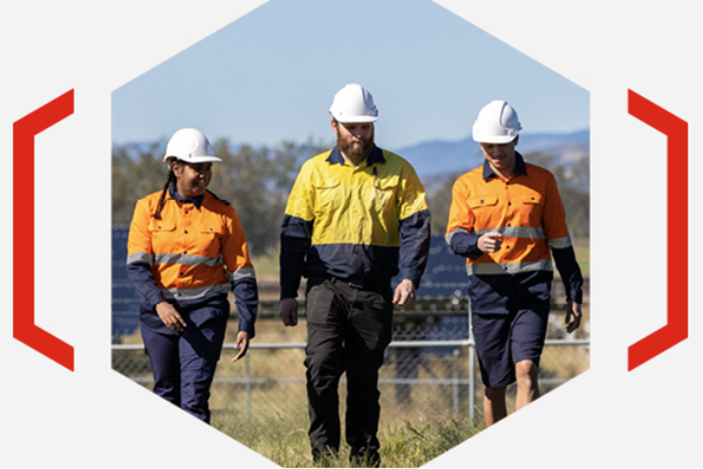Three engineers in a field wearing high-vis